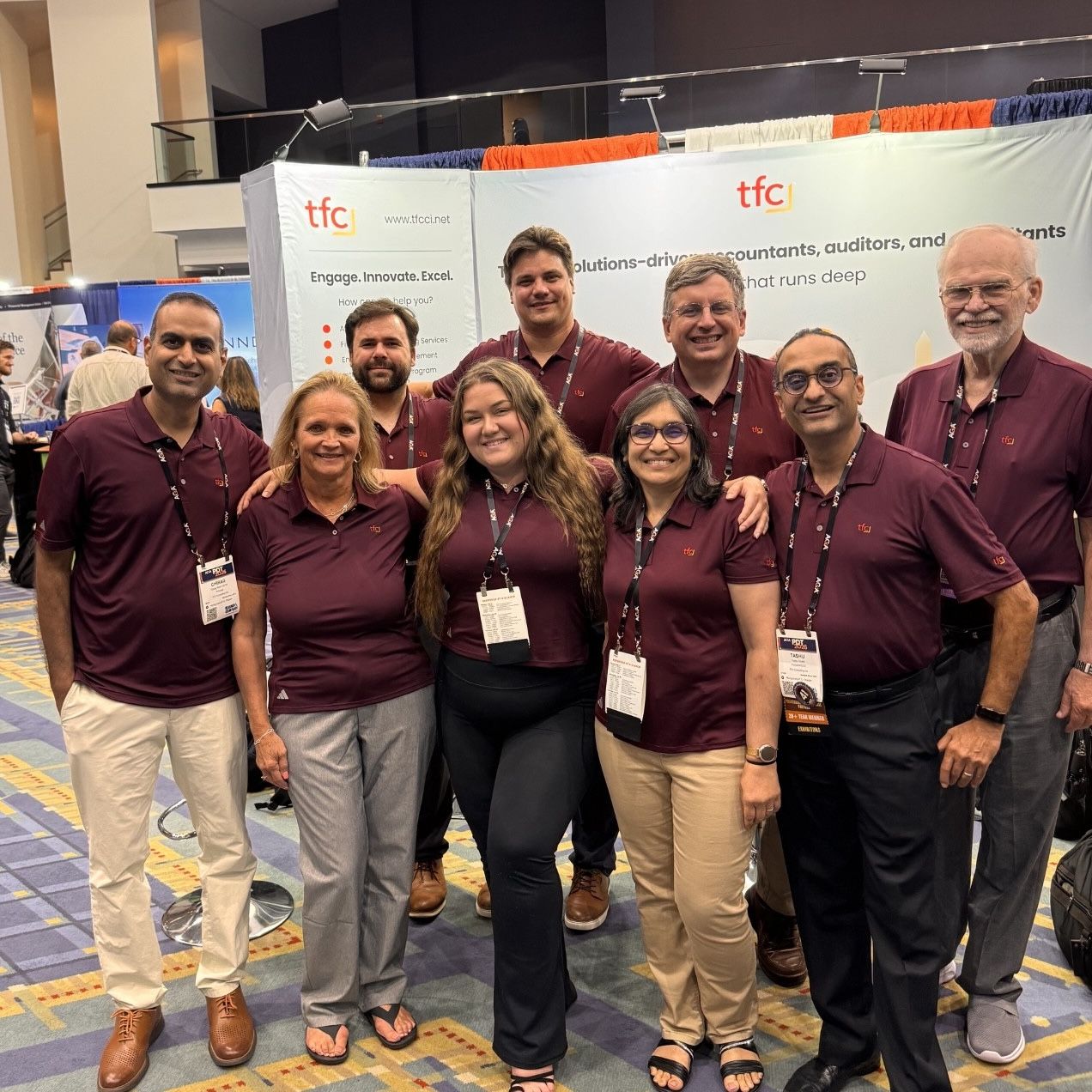 TFC team members stand together at their booth at the conference.